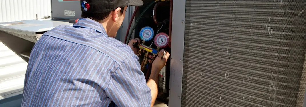HVAC technician servicing a condenser unit in Helena Valley Southeast