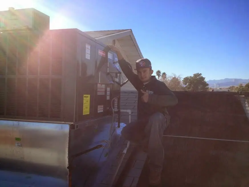 HVAC technician performing AC Tune-Up on a rooftop unit in Helena Valley Southeast